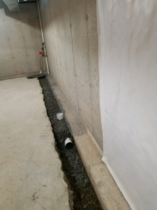 Installation process of our drainage and crushed stone. You can see our port hole opening for flushing out the system when cleaning service is needed.